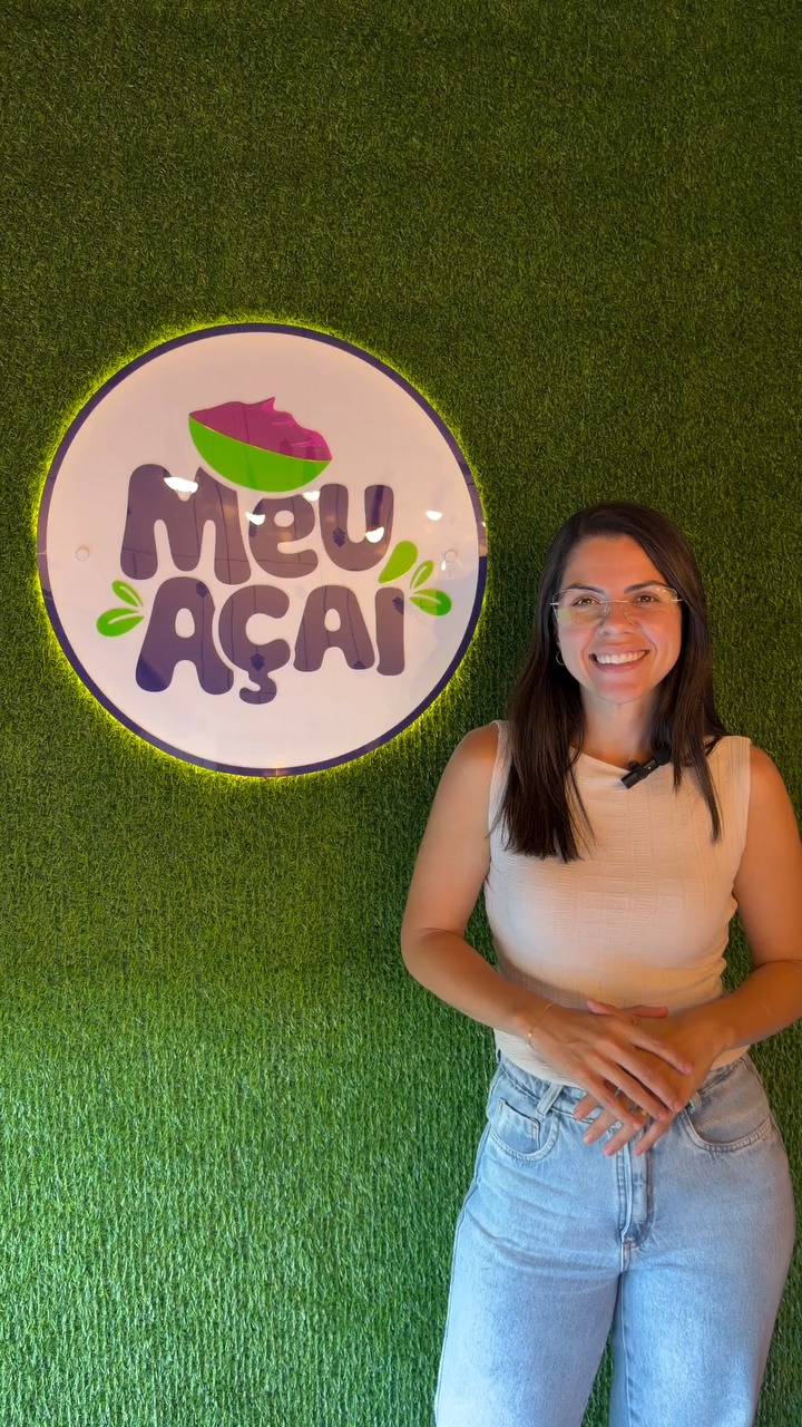 Atendente em frente ao letreiro Meu A&ccedil;a&iacute;